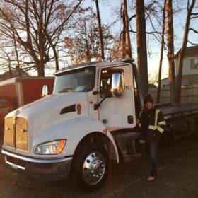 A woman standing next to a white truck.