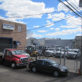 A truck parked in front of a building with cars on the street.