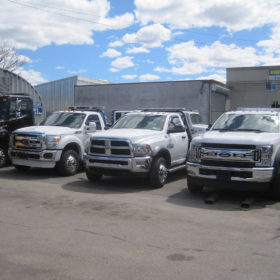 Three trucks parked in a lot next to each other.