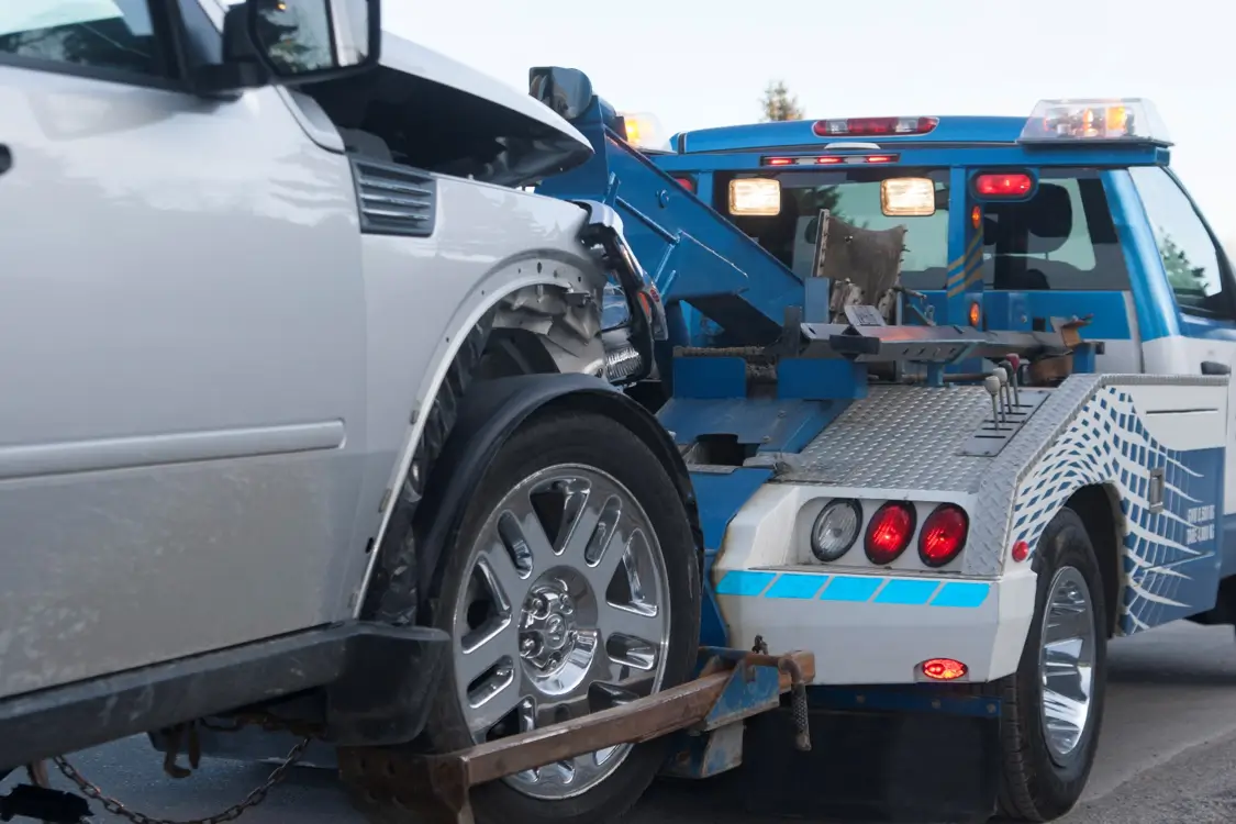 Tow truck towing a damaged car.