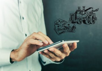 A man holding an ipad in front of a drawing of a truck.