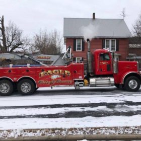 A red tow truck is parked on the side of the road.