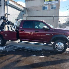 A red tow truck parked in the snow.