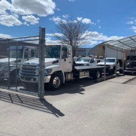 A truck parked in front of a fence.